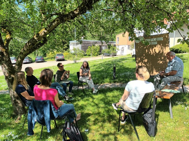 Arbeitskreis im tagt im Grünen unter einem Baum